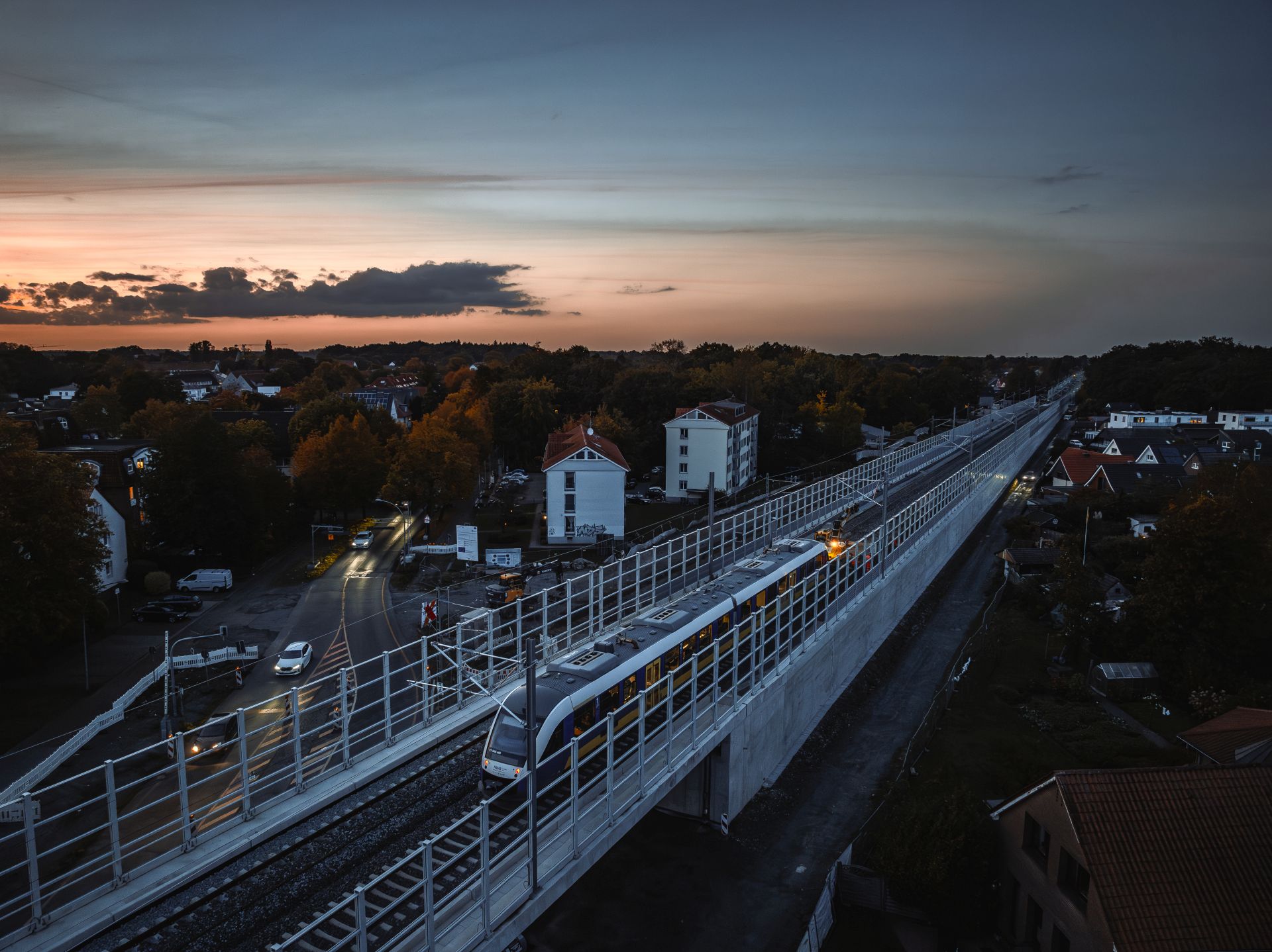 Luftbild der Eisenbahnbrücke Alexanderstraße in der Abenddämmerung mit einem Zug auf den Gleisen